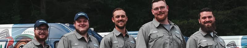 Five crew members in uniform beside company van