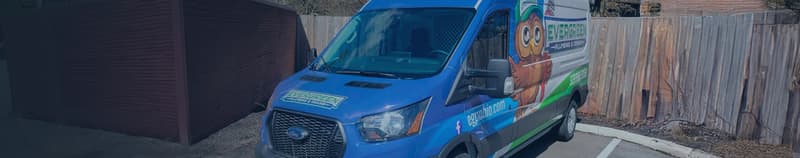 Company service van parked beside a wooden fence
